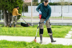 A lawn care crew trimming edges and mowing a residential lawn for Backcountry Lawn Service in Missoula, MT.