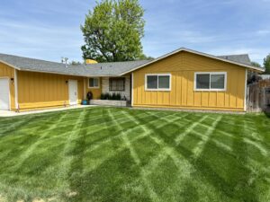 A residential front lawn expertly mowed with a distinctive criss-cross pattern by Luna's Lawn Care LLC in West Des Moines, IA.