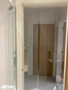 A crystal clear glass shower door after professional cleaning by Nicy Cleaning Service in Danbury, CT.