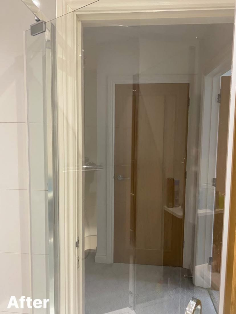 A crystal clear glass shower door after professional cleaning by Nicy Cleaning Service in Danbury, CT.