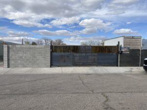 A custom gate featuring the Excellence Garage Doors LLC logo, installed as part of their gate access services in Albuquerque, NM.