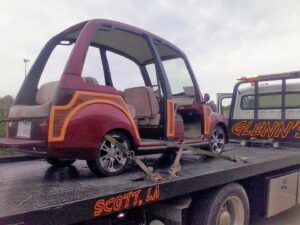 A custom golf cart loaded and secured on a flatbed tow truck from Glenn's Towing & Recovery Inc in Lafayette, LA.
