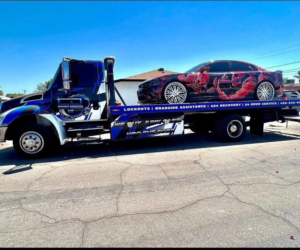 A custom-wrapped sedan being transported on a flatbed tow truck by CnD towing in Phoenix, AZ.