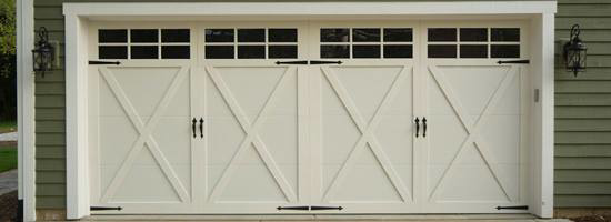 A beautiful custom-style white garage door with windows and decorative hardware installed by Carriage Overhead in Stamford, CT.