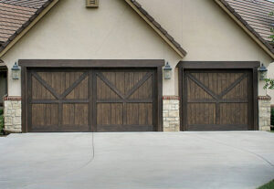 Two custom wooden garage doors with decorative hardware installed by Ultimate Garage Doors LLC in Olive Branch, MS.