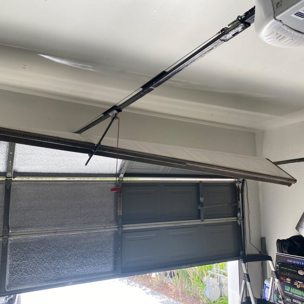 A damaged and bent garage door requiring repair, illustrating a common service provided by American Veteran Garage Door Repair Henderson, NV.