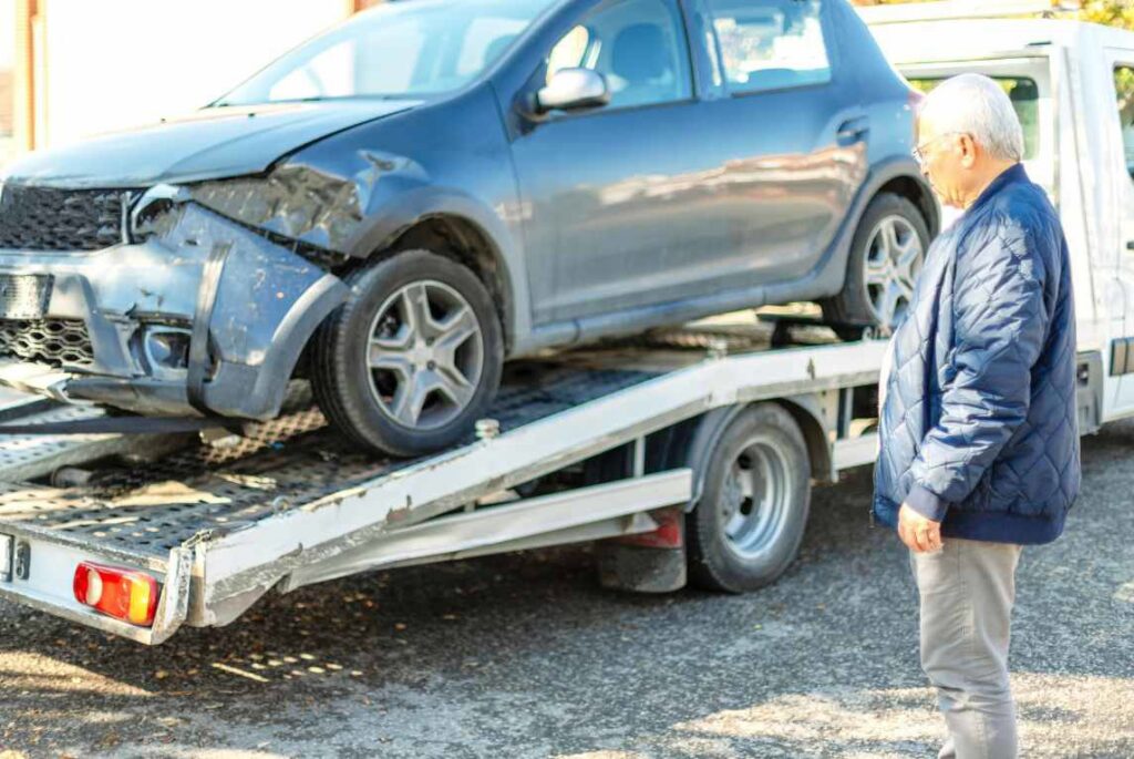 A damaged blue car being loaded onto a flatbed tow truck by Spokane Towing Services in Spokane, WA.