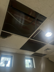 A damaged ceiling with removed tiles and exposed pipes, indicating water damage, handled by HTS Restoration in El Paso, TX.