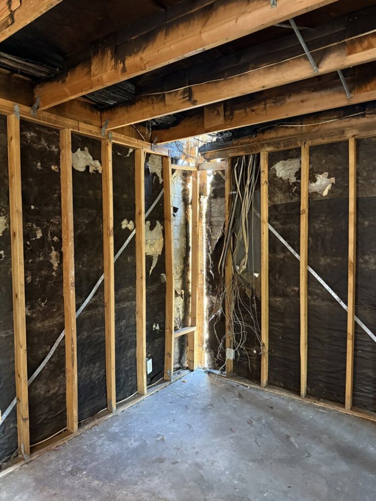 Damaged exposed framing and ceiling joists, showing signs of water damage, by Western Skies Restoration in Gilbert, AZ.
