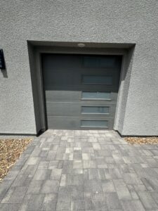 A severely damaged garage door off its tracks, clearly requiring repair from NV Pro Garage Doors in Las Vegas, NV.