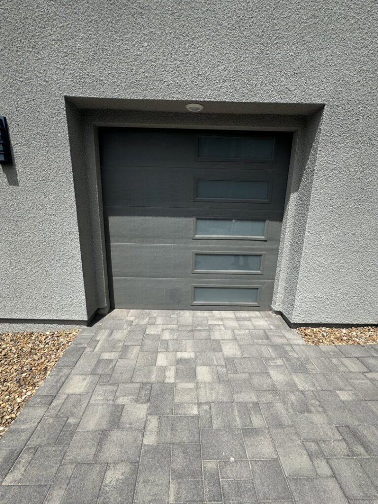 A severely damaged garage door off its tracks, clearly requiring repair from NV Pro Garage Doors in Las Vegas, NV.