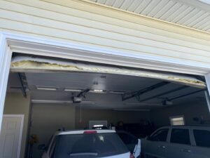 A damaged garage door requiring repair or replacement services from J.A. Overhead Door in Westfield, MA.