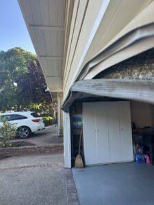 A residential garage door showing a potential issue with the track or panel, indicating a need for repair by Carmichael Garage Door in Carmichael, CA.