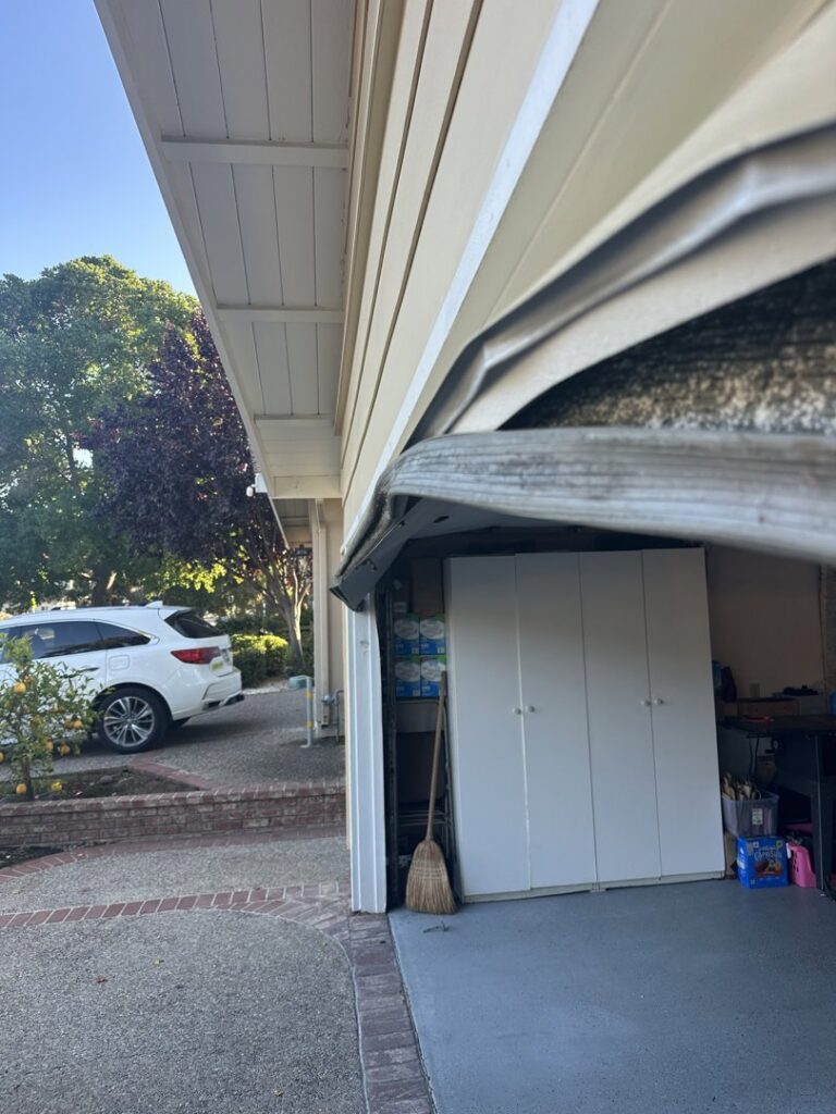 A residential garage door showing a potential issue with the track or panel, indicating a need for repair by Carmichael Garage Door in Carmichael, CA.
