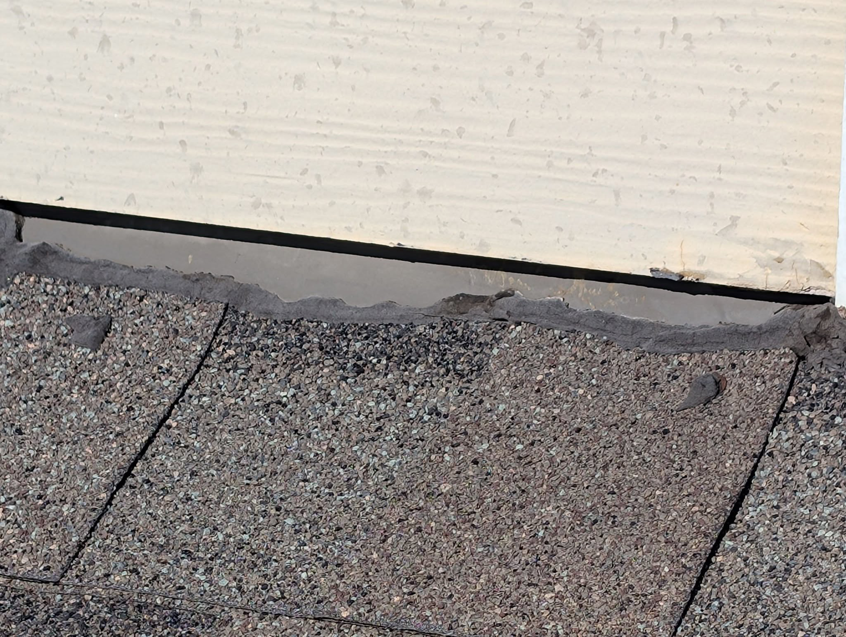Damaged roof flashing at a wall junction, a common source of water intrusion, repaired by Exterior Repair Medics in Manhattan, KS.