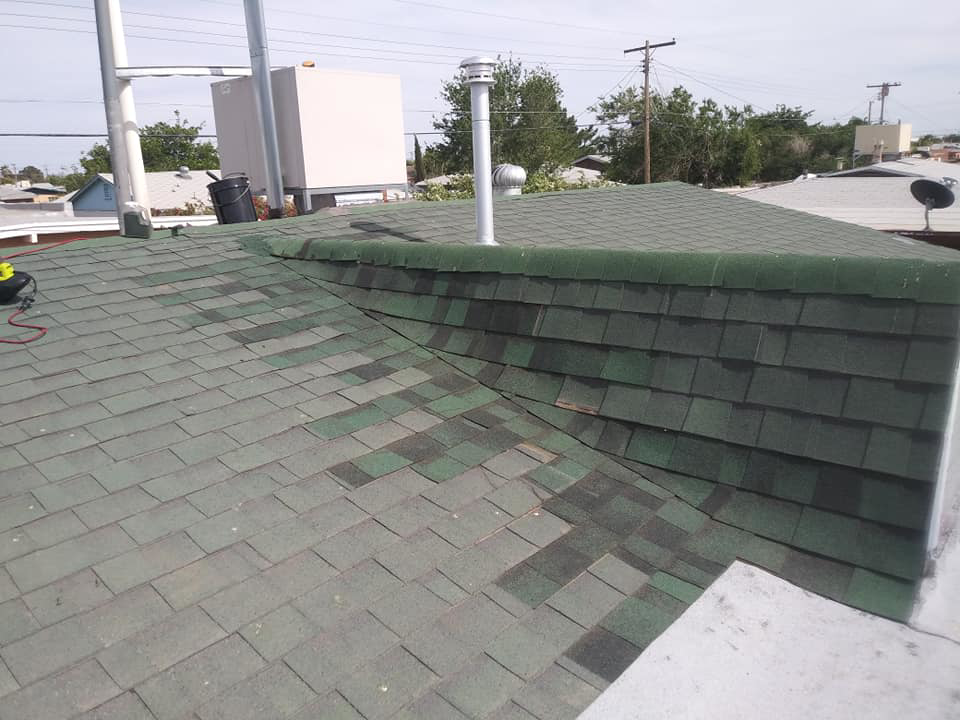 A damaged shingle roof with discoloration and missing shingles, indicating a need for water damage repair by DryTech in El Paso, TX.