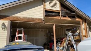 Damaged siding above a garage door requiring repair by Good Life Construction Inc in North Highlands, CA