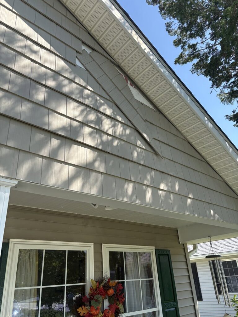 Close-up of damaged siding on a house, indicating a need for repair by PJ Fitzpatrick LLC in New Castle, DE, often caused by water.