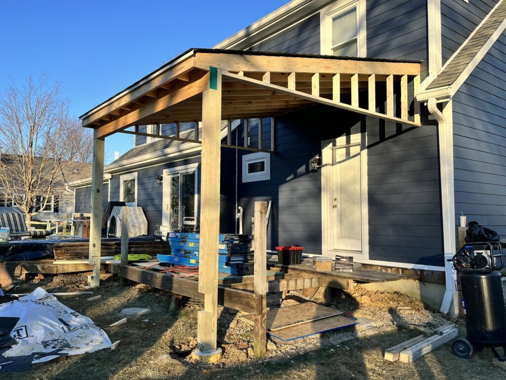 A home with dark blue siding and a wooden patio cover under construction by Stephenson Exteriors LLC in Cincinnati, OH.