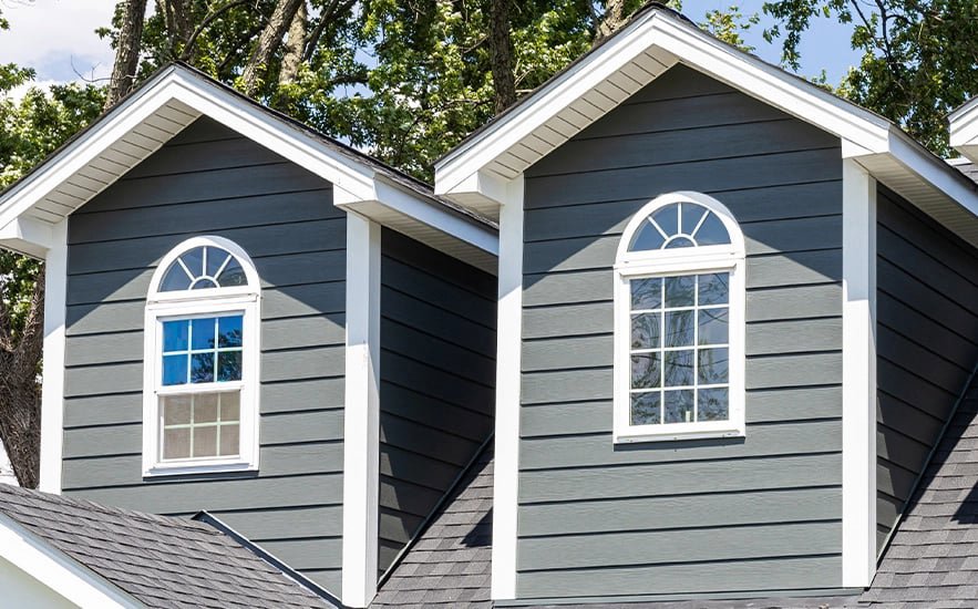 A residential home featuring dark gray horizontal and shake siding installed by Bushco Contracting LLC in Fresno, CA.