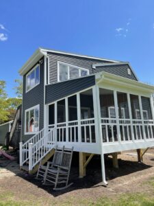 A modern home with new dark gray horizontal siding and a screened-in porch by Atlantic Roofing and Siding in East Hartford, CT.