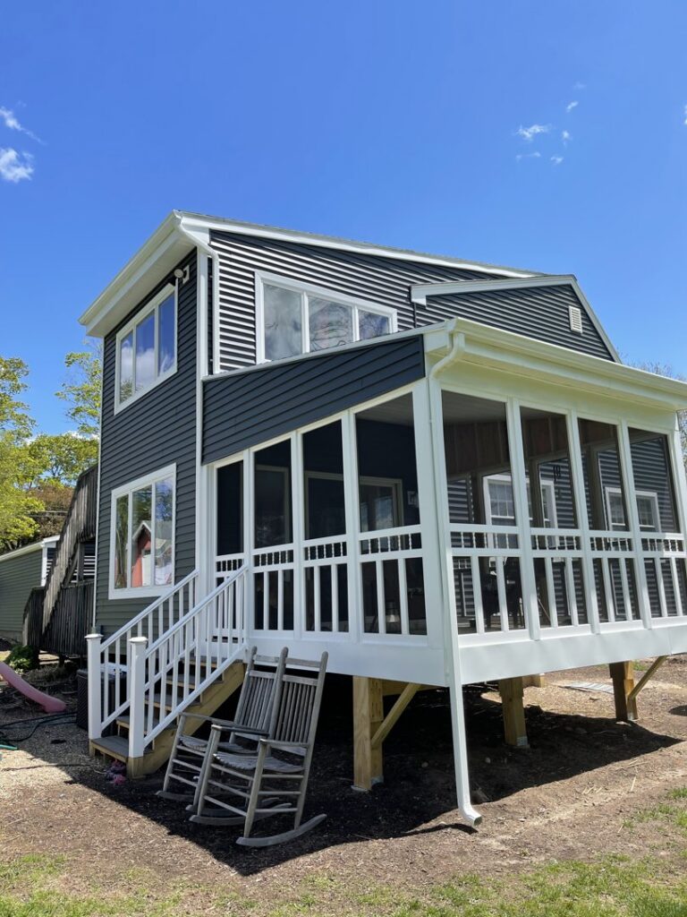 A modern home with new dark gray horizontal siding and a screened-in porch by Atlantic Roofing and Siding in East Hartford, CT.