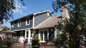 The back of a residential house showcasing dark gray siding and white trim installed by Ideal Siding Winston-Salem, NC.