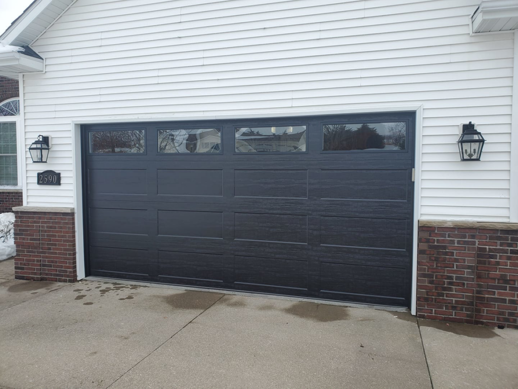 A dark grey garage door replacement completed by 74 Garage Door Company in Lake Park, FL