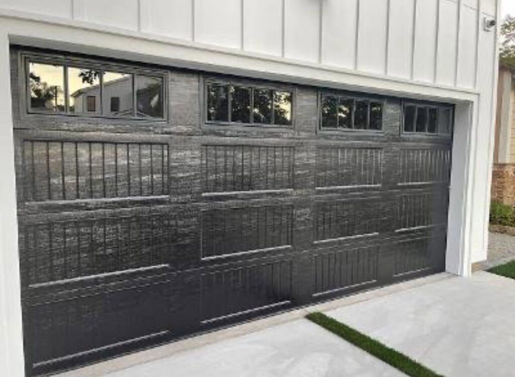 A dark grey textured garage door with top windows, showcasing an installation by NV Pro Garage Doors in Las Vegas, NV.