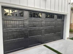 A dark grey textured garage door with top windows, showcasing an installation by NV Pro Garage Doors in Las Vegas, NV.