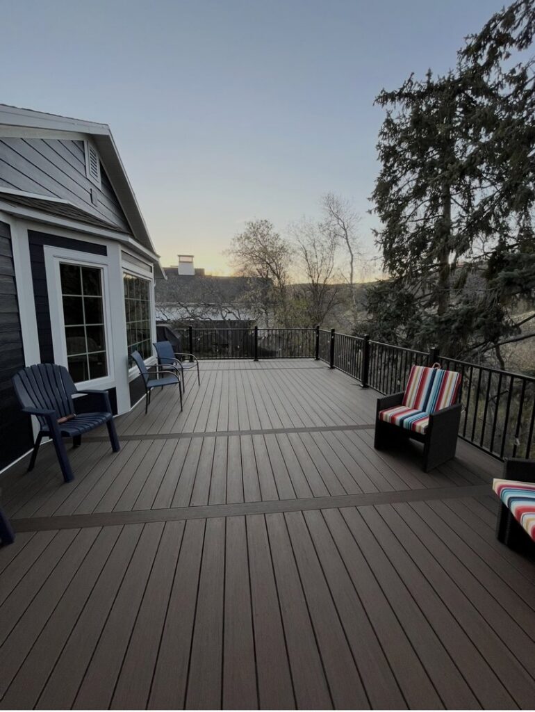 The side of a house with dark horizontal siding and a spacious deck, installed by New Look Siding in Midvale, UT.