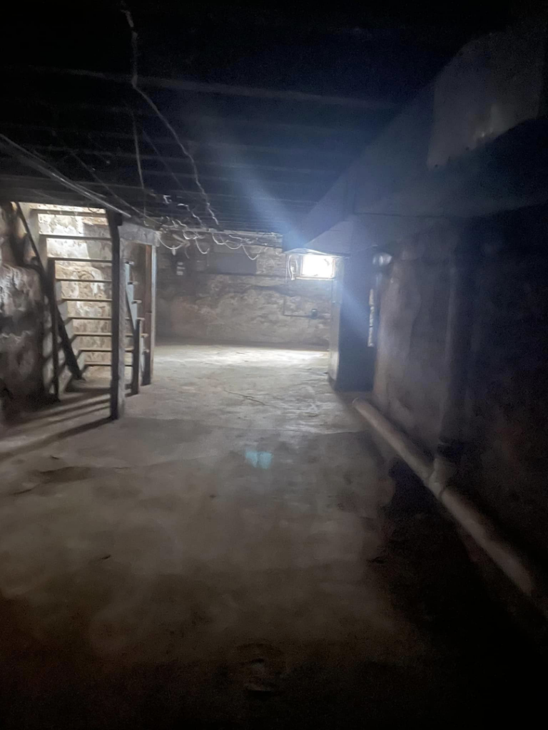 A dark, unfinished basement showing exposed joists and rough walls, ready for demolition by Identical Demolition LLC in Philadelphia, PA.