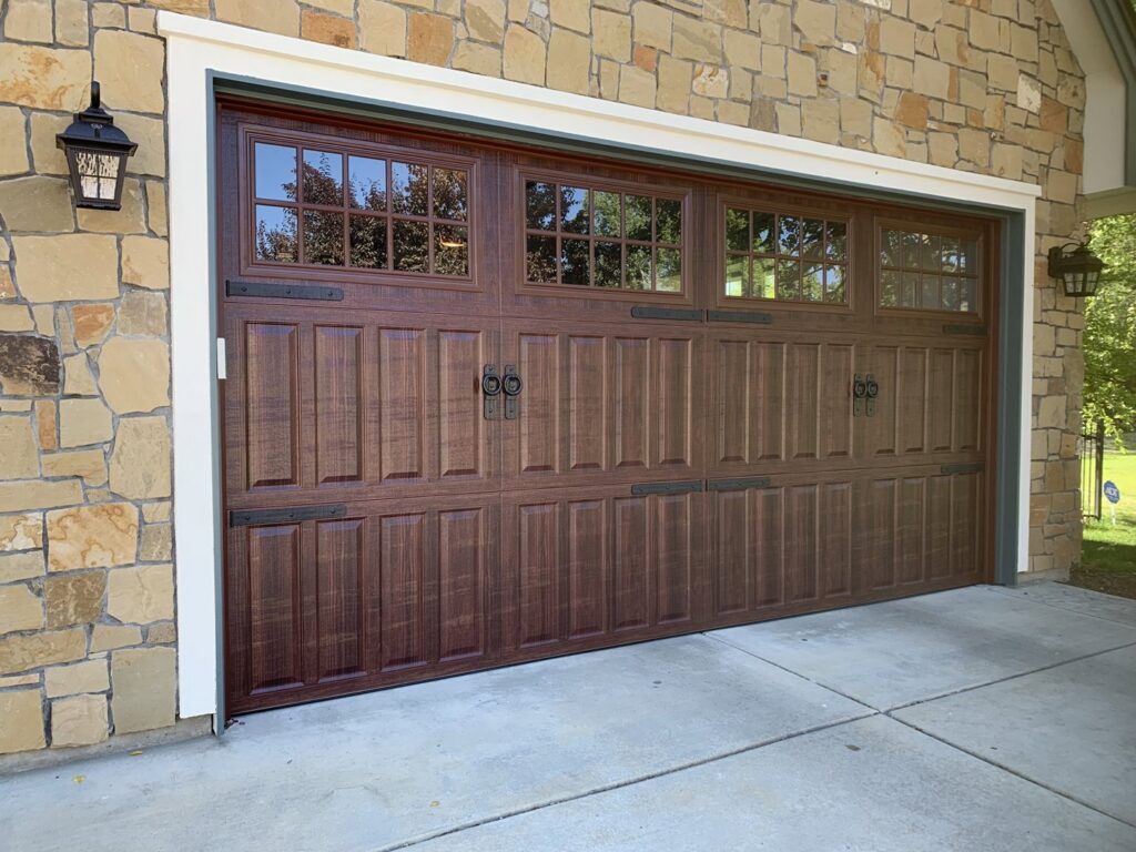 Beautiful dark wood-look garage door with decorative hardware installed by Garage Door Store Boise, ID.