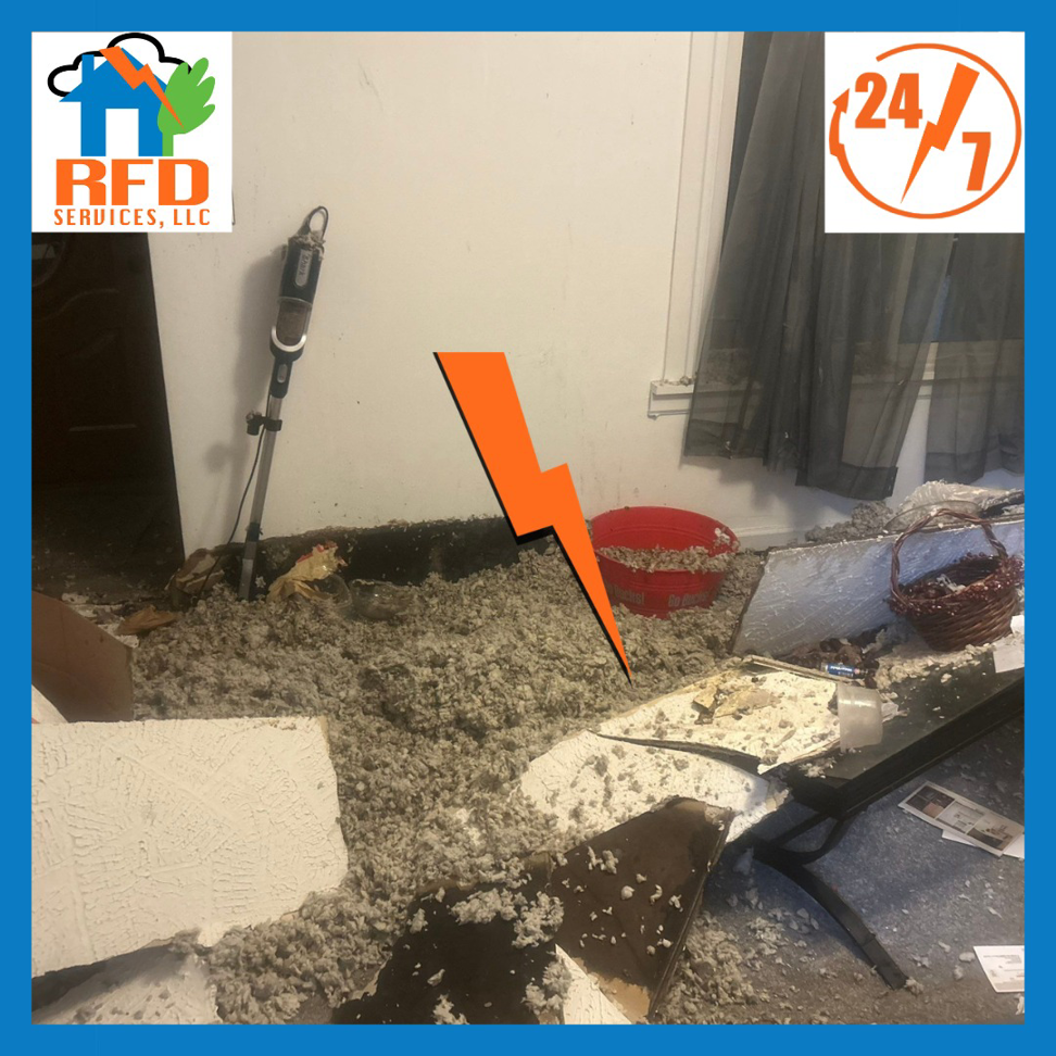 Debris and insulation on the floor from water damage, with a vacuum cleaner, handled by RFD Services in Akron, OH.