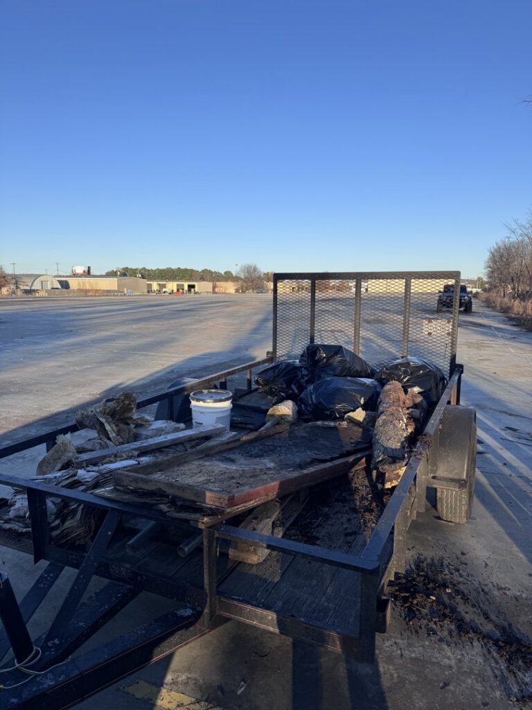 A trailer loaded with debris and trash bags after a cleanup by All in- Landscaping and Power-washing in Fayetteville, AR.