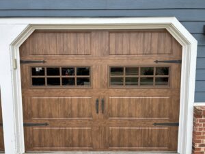 A stylish brown garage door with windows and decorative hardware installed by Woodwards Overhead Door Co. in Topeka, KS