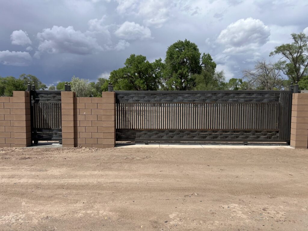 A newly installed decorative metal gate with brick pillars by Excellence Garage DOORS LLC in Los Angeles, CA