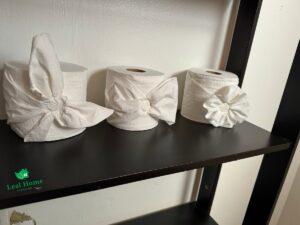 Decoratively folded toilet paper rolls on a shelf, a detail from Leal Home Cleaning in San Francisco, CA.