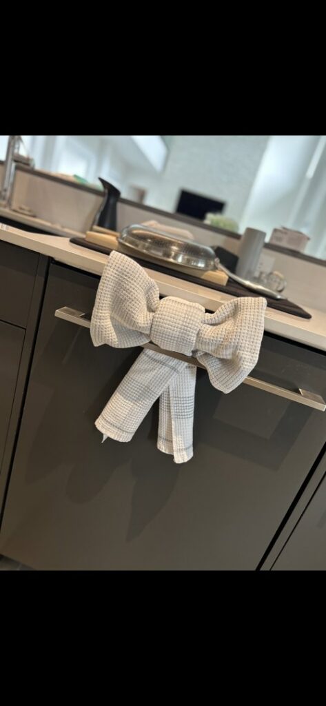 A decorative towel tied in a bow on a kitchen cabinet handle, a detail from We Maid It Two Cleaning Services LLC in Owensboro, KY.