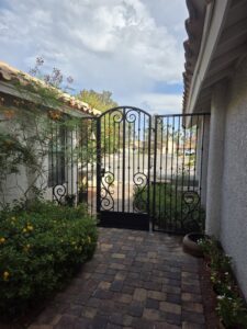 A decorative wrought iron courtyard gate installed by Giddy Up Garage Doors & Iron in Las Vegas, NV.