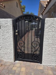 A decorative wrought iron pedestrian gate at an entry installed by Giddy Up Garage Doors & Iron in Las Vegas, NV.
