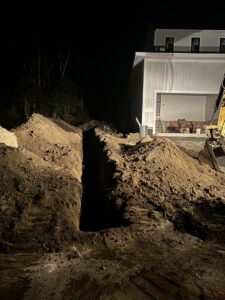 A deep trench dug next to a house foundation for waterproofing or drainage by Fleury Dirt Works & Services Llc in Cumberland, RI