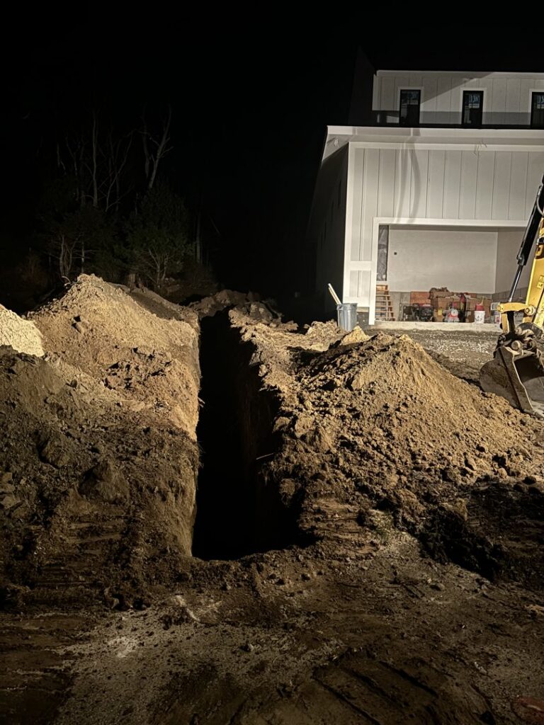 A deep trench dug next to a house foundation for waterproofing or drainage by Fleury Dirt Works & Services Llc in Cumberland, RI