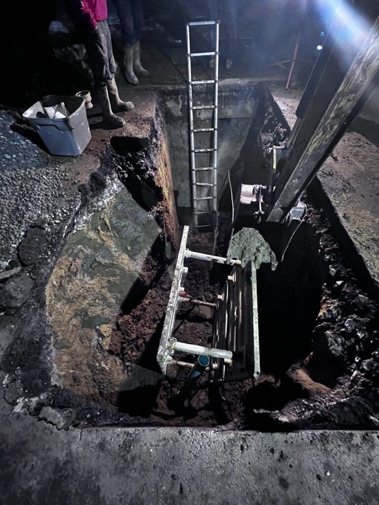 A deep trench with ladders and standing water for a major plumbing repair, handled by Mr. Rooter Plumbing of Youngstown, OH.