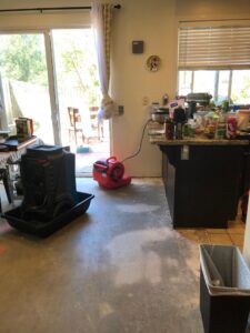 A dehumidifier and air mover in a kitchen undergoing water damage drying by EZ Water Damage Restoration Services in Chula Vista, CA.