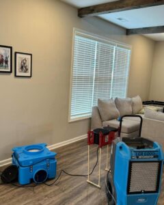 A dehumidifier and air mover running in a living room, used for water damage drying by KY Water Damage Restoration in Georgetown, KY.
