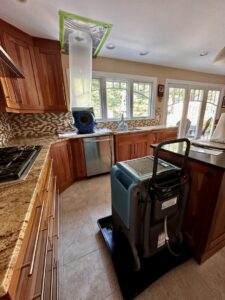 A dehumidifier and air scrubber working in a kitchen during water damage restoration by New Method Restoration in Edison, NJ.