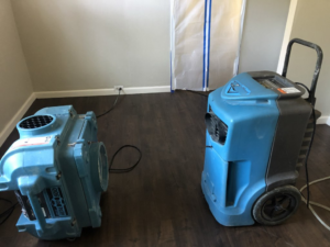 Two industrial dehumidifiers and a containment barrier set up for water damage drying by Bordi Restoration in San Leandro, CA