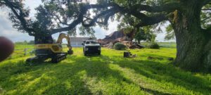 A completely demolished house site with an excavator and truck for debris removal by Judice Dirt & Demolition in Lafayette, LA.