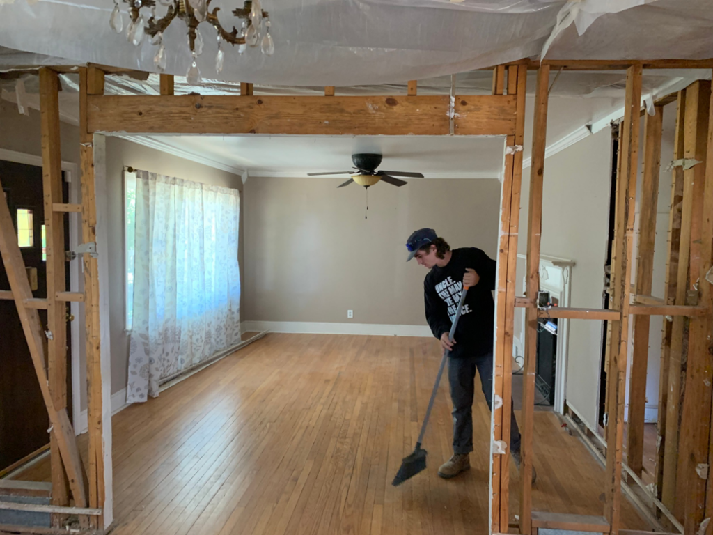 A worker sweeping debris in a room after wall demolition by Clean Slate Demolition in Rock Hill, SC.